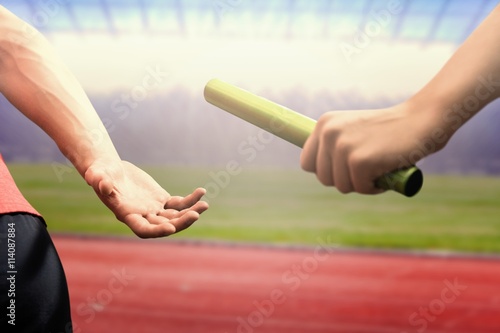 Obraz na plátne Composite image of athlete passing a baton to the partner