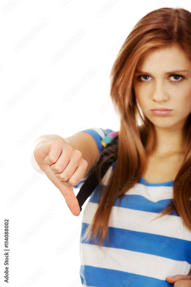 Young unhappy teenage woman shows thumbs down Young unhappy teenage woman shows thumbs down