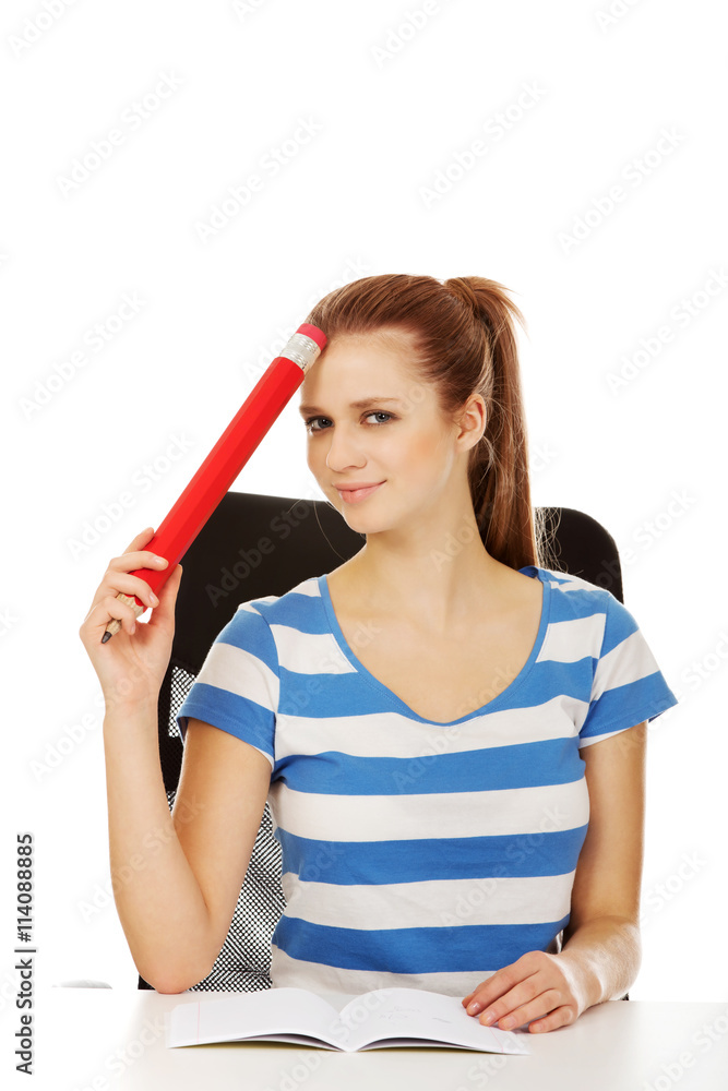 Pretty teenager woman holding huge pencil. Pretty teenager woman holding huge pencil.