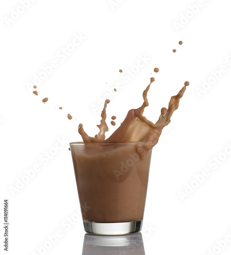 chocolate milk or protein milkshake flowing into a glass, making  big splash, isolated on white background