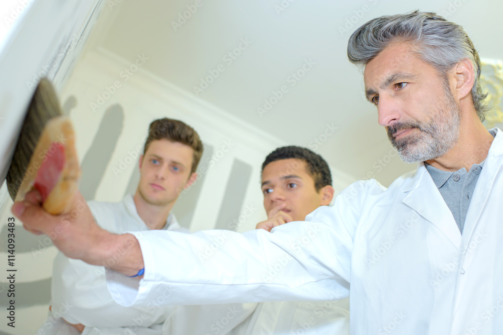 Obraz premium Students watching teacher use dusting brush