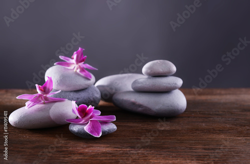 Spa stones and flowers on grey background