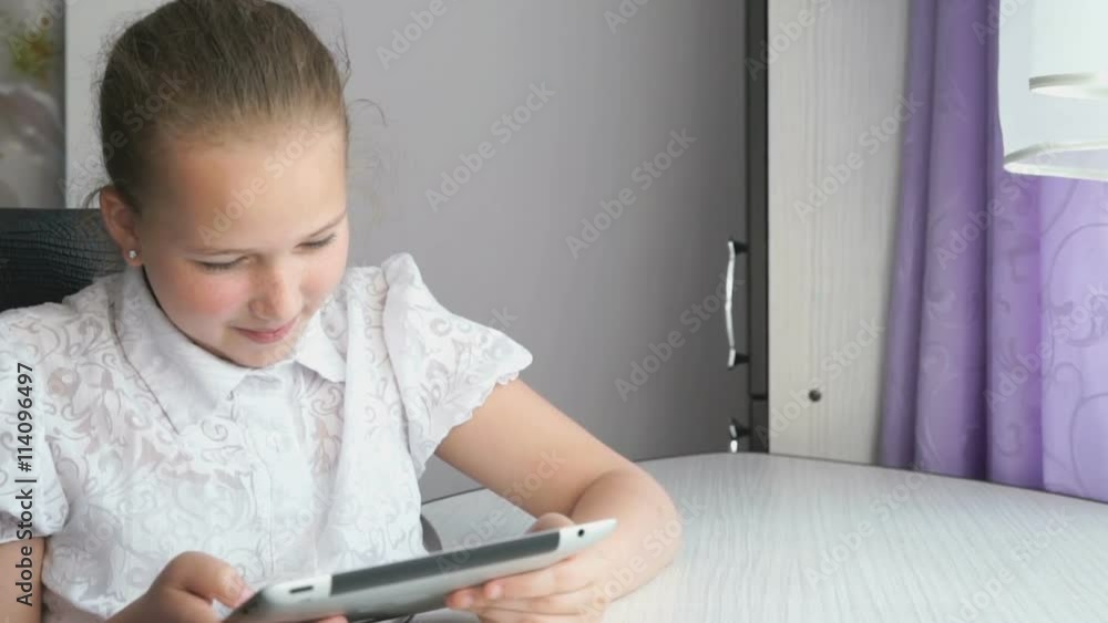 Cute little girl uses a digital tablet computer Cute little girl uses a digital tablet computer