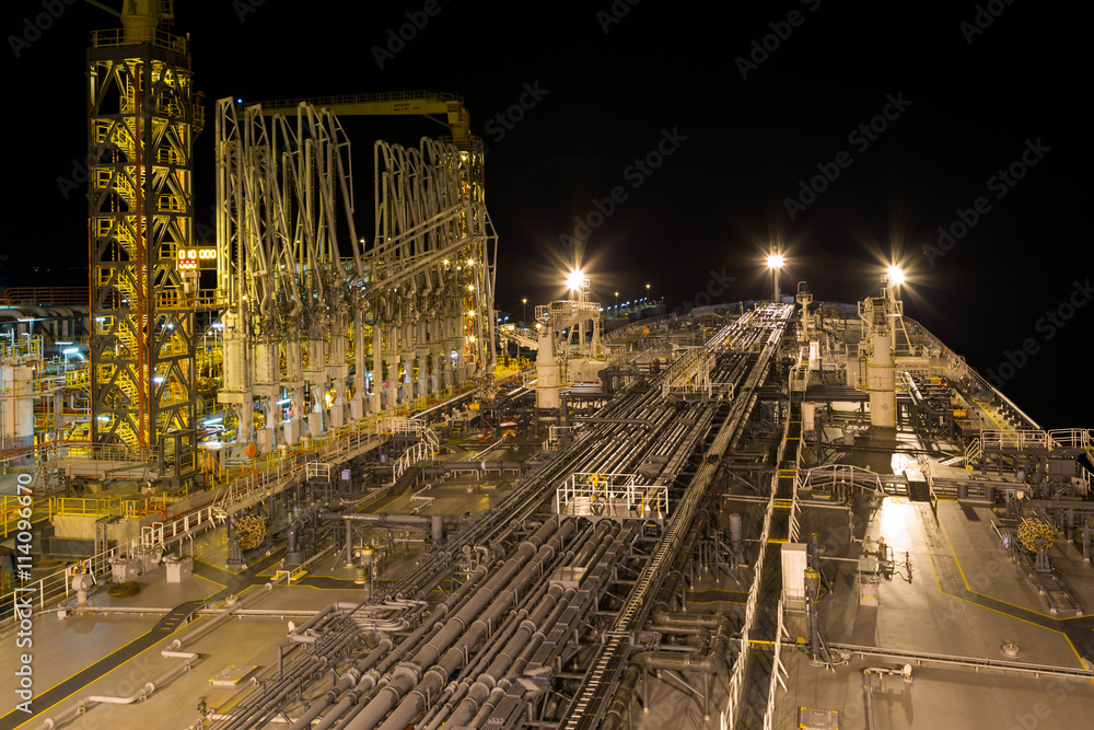 Oil terminal with moored tanker at night.