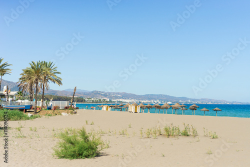 Mediterranean beach with palmtrees and blue sky
