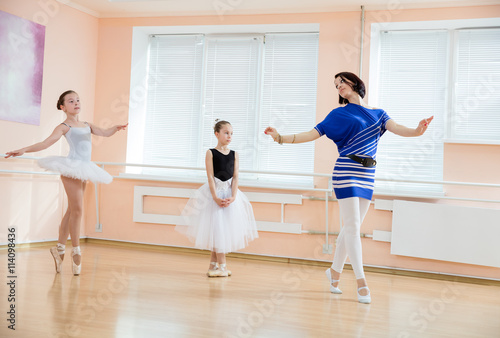Ballet teacher and young students at dance class