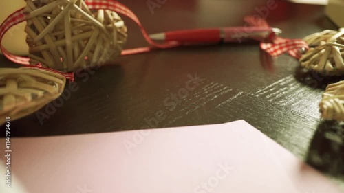 Girl hand putting down an envelope with a red lipstick stamp on it. Close up photo