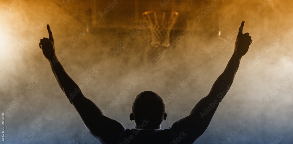 Obraz premium Rear view of a basketball player with his arms in the air