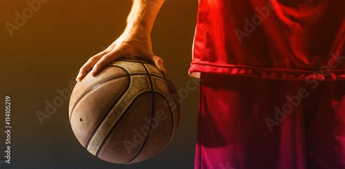 Close up on a basketball held by basketball player © vectorfusionart