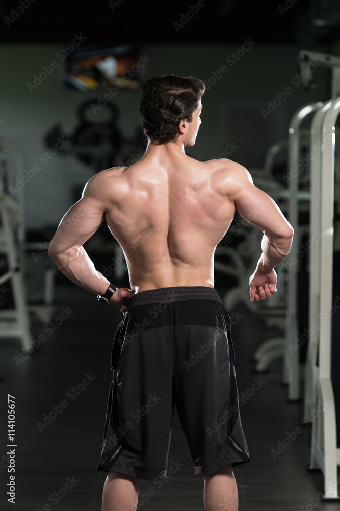 Muscular Man Flexing Back Muscles Pose