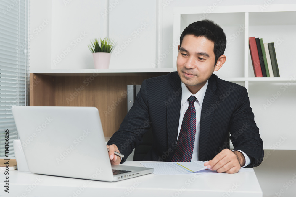 Handsome Asian businessman using laptop computer