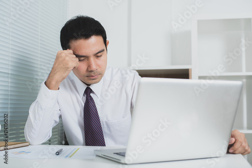 Asian businessman getting stressed at work