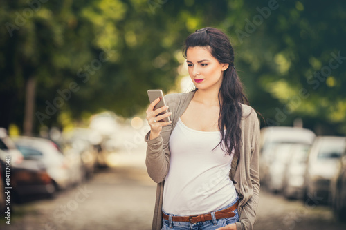 Girl using cellphone outdoors.