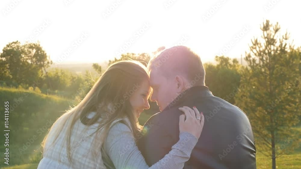 back view of young happy couple sitting at sunset back view of young happy couple sitting at sunset