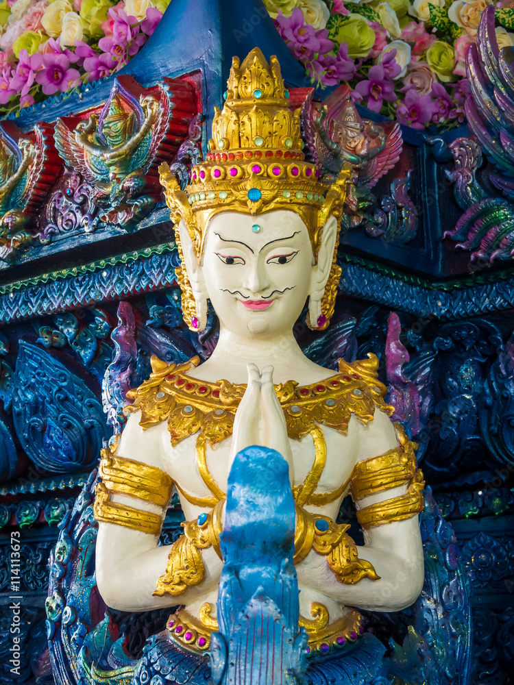 Thai sculpture style of beautiful angel statue in put the palms of the hands together in salute at the temple in Chiang Rai, Thailand