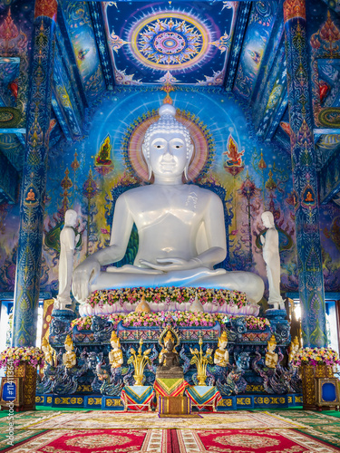 Big white jade statue of "the Buddha calling the earth to witness or earth touching Buddha" and wonderful mural in blue chapel at the temple in Chiang-Rai, Thailand