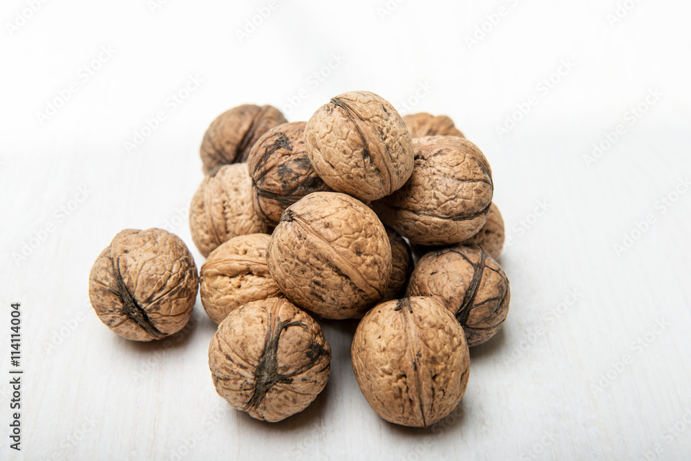 Heap of walnuts on white table Heap of walnuts on white table