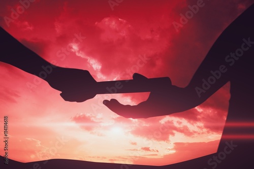 Composite image of  man passing the baton to partner on track photo