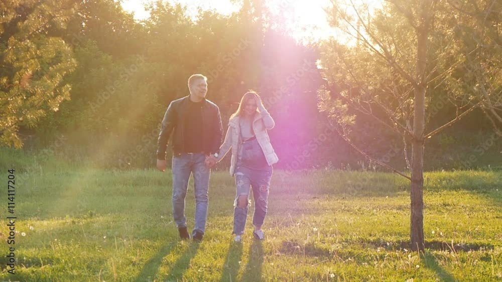 lovers walking in a field at sunset lovers walking in a field at sunset