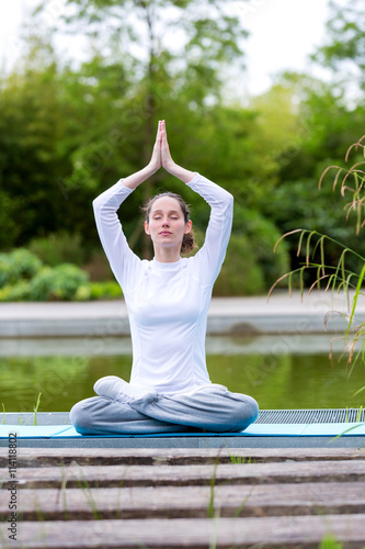 View of a Young attractive woman practising yoga in a park