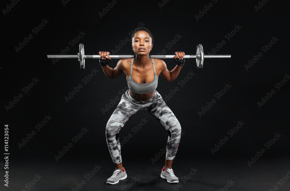 Close-up portrait of fitness girl doing squats with barbell Close-up portrait of fitness girl doing squats with barbell