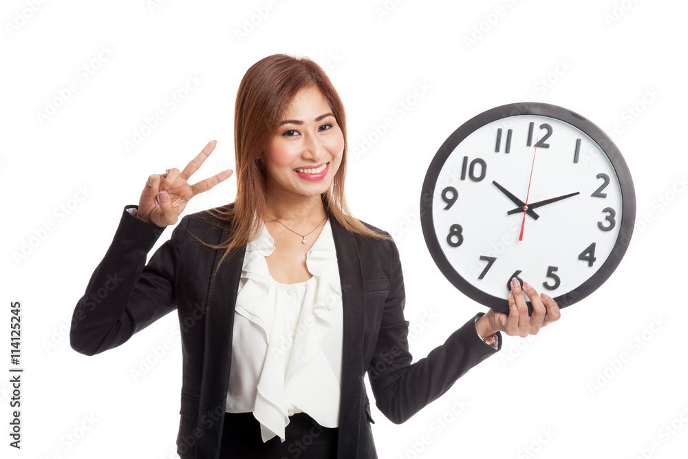 Young Asian business woman show victory sign with a clock Young Asian business woman show victory sign with a clock