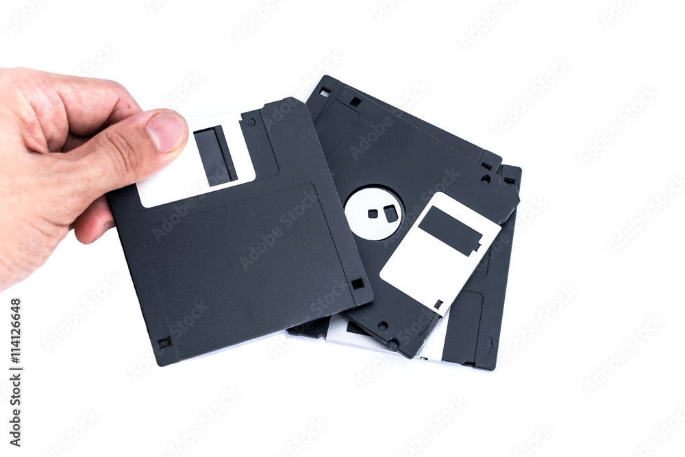 The old technology of storage - Hand holding Black Floppy Disk. isolated on white background for your text and design The old technology of storage - Hand holding Black Floppy Disk. isolated on white background for your text and design