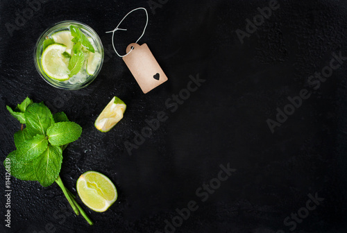 Fresh juicy mojito in glasse on a dark stone background, top view
