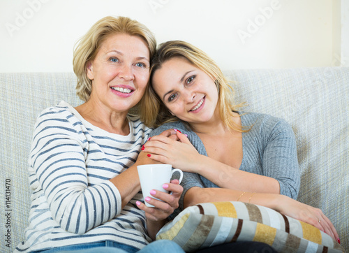 Portrait of happy mature mother and young daughter at home