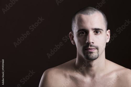 Natural portrait of guy in studio over brown background