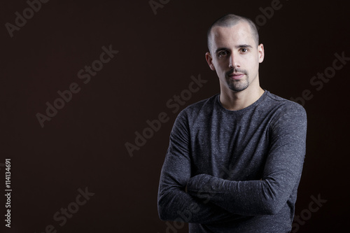 Natural portrait of guy in studio over brown background