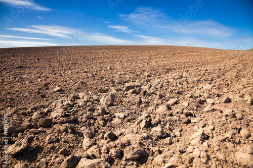 Agricultural background with plowed field and blue sky Fototapet