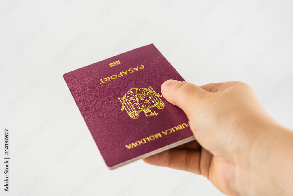 Hand with a passport of a citizen of Moldova on a white background Hand with a passport of a citizen of Moldova on a white background