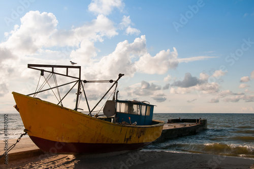 Yellow boat on the beach evening time