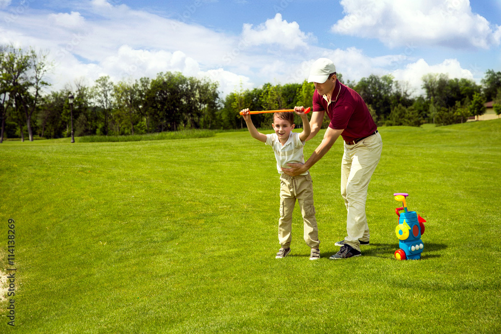 Fototapeta premium Father with son are training at golf course