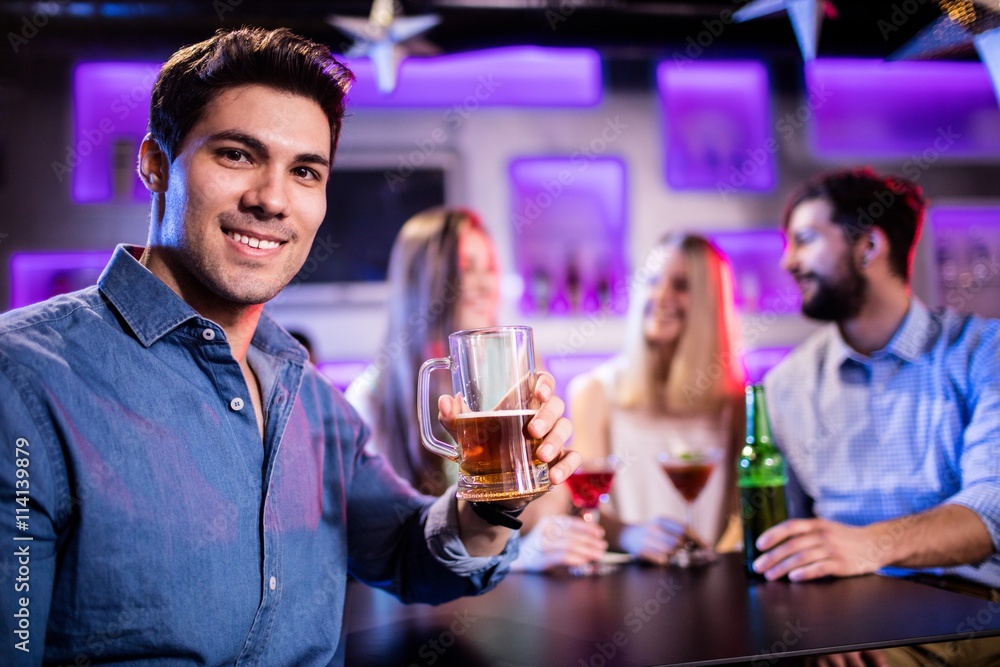 young man having glass of beer at bar counter