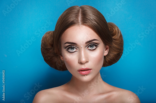 Schilderij op canvas Attractive mysterious young woman with double hair bun in Princess Leia hairstyl