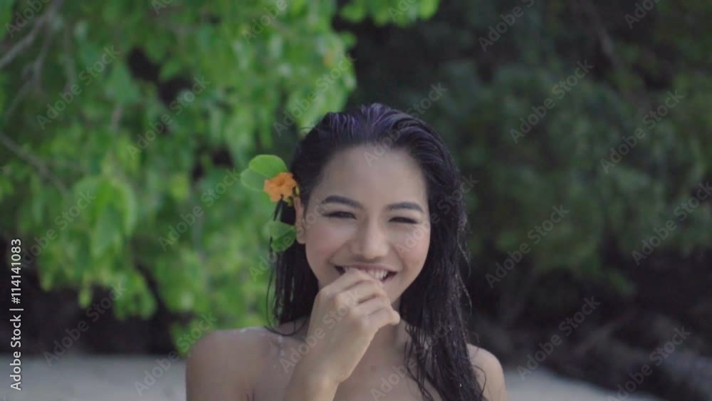 Asian beautiful happy woman in crochet bikini walking on the beach. Video of sexy smiling girl walking on the beach with the flower in her hair in slow motion. Asian beautiful happy woman in crochet bikini walking on the beach. Video of sexy smiling girl walking on the beach with the flower in her hair in slow motion.
