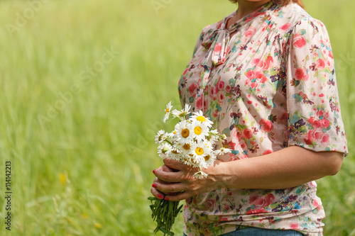 The female hand hold a white camomiles © Andrey Cherkasov