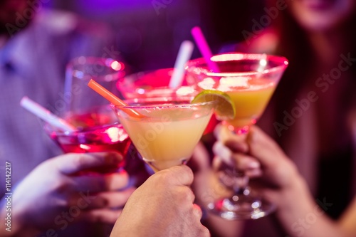 Group of friends toasting cocktail at bar counter