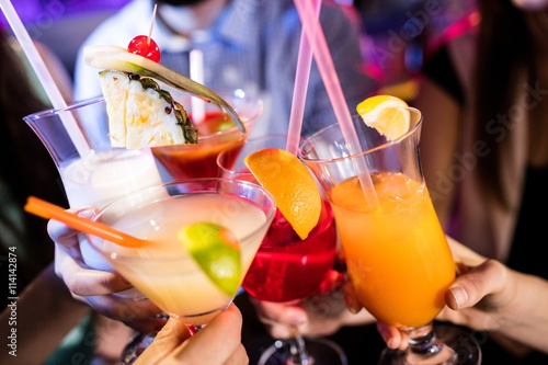 Foto Group of friends toasting cocktail at bar counter