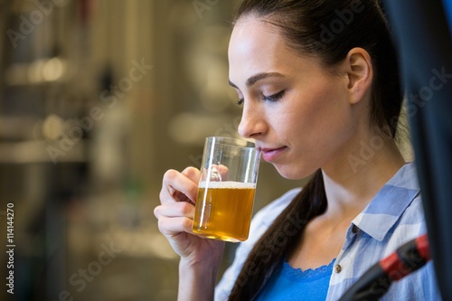 Female brewer testing beer