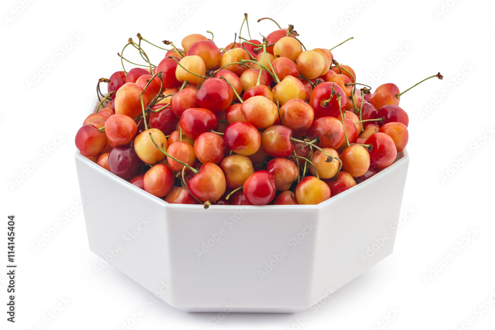 White hexagonal bowl filled with fresh ripe organic Rainier cherryes isolated on a white background White hexagonal bowl filled with fresh ripe organic Rainier cherryes isolated on a white background