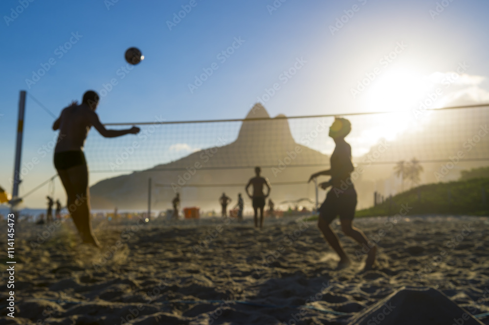Φωτογραφία Silhouettes of Brazilians playing futevolei (footvolley) against a sunset backdr