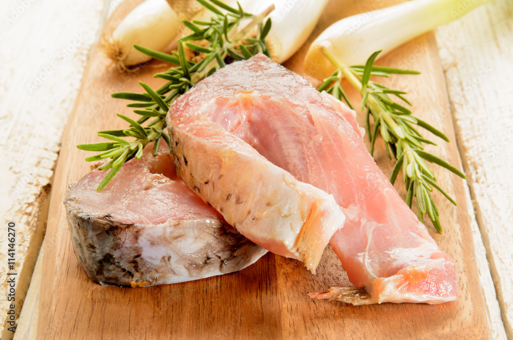 raw carp steak with rosemary and spring onions raw carp steak with rosemary and spring onions