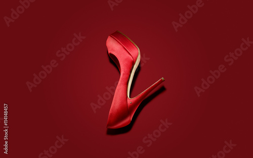 Red high heel shoe on red background