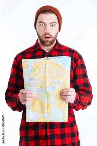Handsome man looking surprised and holding map