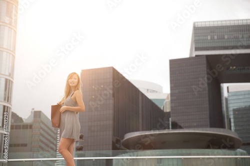 Young woman walking beside harbour, Hong Kong, China photo