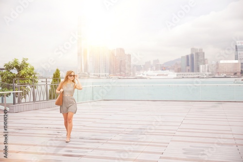 Young woman walking beside harbour, Hong Kong, China photo