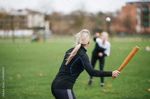 Rear view of female rounders player playing rounders match